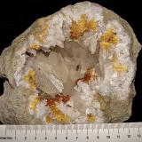 Calcite with Marcasite inclusions on Dolomite and QuartzAfloramientos Carretera Estatal 37, Harrodsburg, Clear Creek, Condado Monroe, Indiana, USAgeode is about 14 cm,  cavity is about 10 cm, largest calcite is about 4.5 cm (Author: Bob Harman)