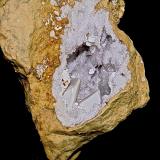 Aragonite or Kaolinite on Calcite on QuartzCondado Monroe, Indiana, USAGeode is 10 cm. the larger of the 2 Calcites is 2.5 cm (Author: Bob Harman)