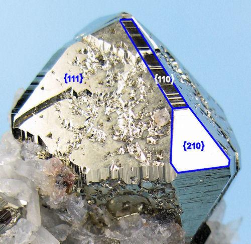 Pyrite, quartz, calcite?
Huanzala Mine, Huallanca District, Dos de Mayo Province, Huánuco Department, Peru

Pay attention to the octahedron {111}, pyritohedron {210} and the uncommon (in pyrite) rhombododecahedron {110} faces. Anyone interested to learn what the Miller indices are can get a primer from the Wikipedia at http://en.wikipedia.org/wiki/Miller_index (Author: Carles Millan)