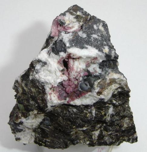 Variscita (roja- 0,7 a 1,8cm) com frondelita (marróm), rockbridgeíta (negra) e albita (blanca). Pegmatito de Boa Vista, Galiléia- MG- Brasil (Autor: Anisio Claudio)