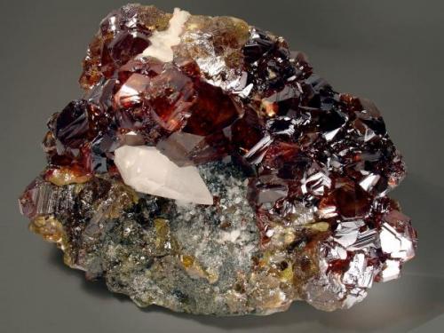 Magnífico grupo de cristales de esfalerita, con un escalenoédro de calcita y pequeños cristales de dolomita. Tercera planta de la mina "Las Manforas". Dimensiones 14 x 10 cm.
Fotografía: J. R. García (Autor: JRG)