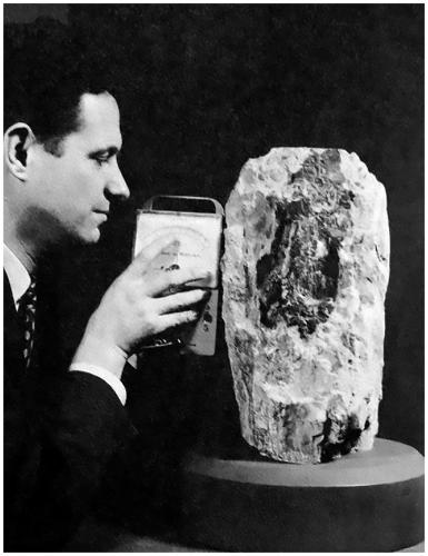 Uraninite at the AMNH – The American Connection

Included for comparison is a photograph of what might be the third largest Uraninite specimen to be publically exhibited in recorded history. The specimen weighed just over 60 kilograms and consisted of an inner core of Uraninite covered in a ‘deliciously’ thick layer of Schoepite. It was exhibited for many years at the American Museum of Natural History (AMNH). In the photograph Dr. Brian H. Mason (1917-2009) Curator of the Department of Physical Geology and Mineralogy at the Museum (1953-1965) can be seen measuring the radiation from the superb specimen. The specimen was donated to the AMNH in 1955 by Vernon J. Pick and it came from the Pick’s Delta Mine, San Rafael Swell Mining District, Emery County, Utah, USA.  What a fine specimen to have in a private collection – the mineralogical stories it could tell and the secrets it could reveal – truly amazing and absolutely beautiful! 

I think some folks might find the following piece of historical trivia interesting. Dr. Mason was an expert on meteorites and was the first scientist to suggest that some meteorites found in Antarctica were in fact moon rocks. Between 1962 and 1965 Dr. Mason took part in several Australian-American expeditions to the clay pans in central South Australia in search of Australites (Tektites). The Australian team was led by R.O Chalmers, Curator of Minerals at the Australian Museum and the man largely responsibility for the acquisition of the fantastic specimen of Uraninite from El Sherana. Dr. Mason also had two minerals named in his honour, Brianite a Sodium-Calcium-Magnesium phosphate mineral (Na2CaMg(PO4)2) and Stenhuggarite a rare Calcium-Iron-Antimony mineral (CaFeAs2SbO7). The mineral name Stenhuggarite is a clever use of the Swedish word Stenhuggare for stonemason honouring Dr. Mason’s work as the proverbial stone man. Asteroid 12926 Brianmason is also named in his honor. In 1965 he became Curator of Meteorites in the Department of Mineral Sciences at the Smithsonian Institution in Washington, retiring in 1984. (Photo courtesy of B. Kramer). (Author: silvia)
