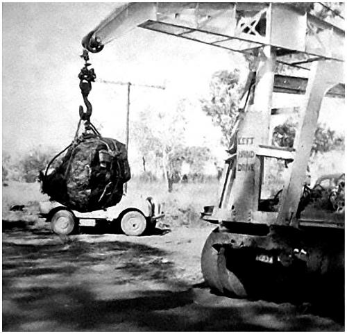 Uraninite being loaded

El Sherana yielded the largest single piece of Uraninite ever produced in the world. It weighed 850 kilograms (1,856 pounds). It was recovered at the El Sherana mine in May 1956. The specimen was purchased by the Australian Atomic Energy Commission for exhibition in Sydney. In the photo the specimen has been hoisted with the aid of a portable crane for loading into a suitable transport vehicle. (Original photo courtesy of F. Jones) (Author: silvia)