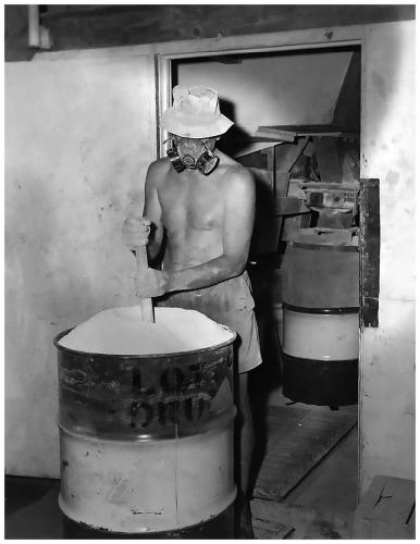 Processing El Sherana Uranium ore at moline

Shown is a photo of a worker ‘settling’ the Uranium ore concentrate into an appropriate steel container in a well-ventilated area. United Uranium N.L., Moline, Northern Territory, 1963. (Photo courtesy of J. Taylor)

The light colour of the product shown in the photo is indicative of Ammonium Uranyl Carbonate (AUC), commonly known as yellow-cake. An alternative compound supplied to the Nuclear Energy Industry is called AUD which is an abbreviation for Ammonium Diuranate, (NH4)2U2O7. AUD is much darker in colour than AUC with a greenish brown hue. For a detailed discussion on the solvent extraction of Uranium from Uranium ores see Ullmann’s Encyclopedia of Industrial Chemistry, 40 Volume Set, 7th Edition, Section U, Uranium, Uranium Alloys, and Uranium Compounds; ISBN: 978-3-527-32943-4. (Author: silvia)