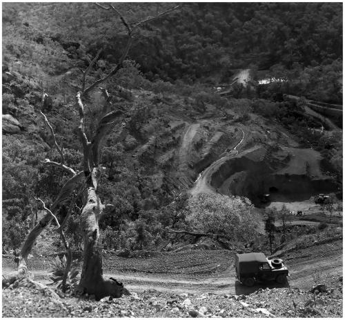 El Sherana West Photo

El Sherana West Open cut ca. 1963. The small open cut was set in some very steep terrain. Clearly visible in the background is the adit leading to the incline shaft which accessed the lower levels from which the bulk of the high grade Uraninite ore was extracted. In the foreground is a jeep bearing the logo of the United Uranium N.L. Company. (Photo courtesy of N. Murphy) (Author: silvia)