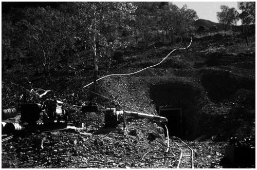 El Sherana Mine Photo showing Adit

An old adit set into a hill at El Sherana, note tracks leading into an adit (perhaps the 195 metre level) and the visible water pipes and machinery, El Sherana, NT late 1950’s. (Photo courtesy of R. Fisher) (Author: silvia)