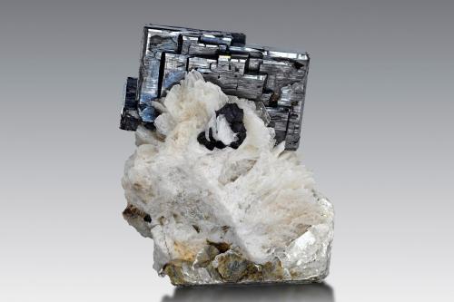 Tantalita-(Fe) en Albita y Moscovita<br />Pegmatita Dara-i-Pech, Distrito Chapa Dara, Provincia Kunar (Konar), Afganistán<br />6 x 5 x 6.5 cm / Cristal principal: 5 cm.<br /> (Autor: Museo MIM)