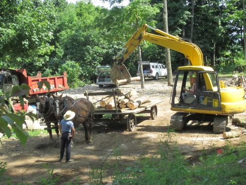 Amish meets excavator. You’ll notice that the wagon has metal wheels, no rubber, and no shoes on the horses. (Author: vic rzonca)