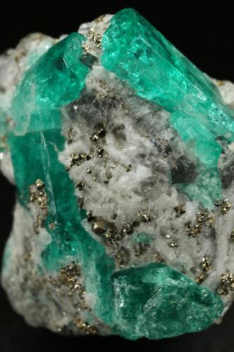 Beryl (variety emerald), Albite (variety cleavelandite), Calcite, Pyrite<br />Chivor mining district, Municipio Chivor, Eastern Emerald Belt, Boyacá Department, Colombia<br />24x26x12mm, largest xl=14mm<br /> (Author: Fiebre Verde)