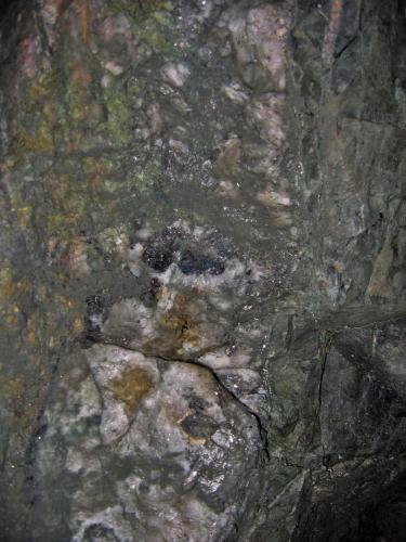 Notice the small ’pods’ of dark Wolframite just above the scheelite occurrence (Author: markbeckett)