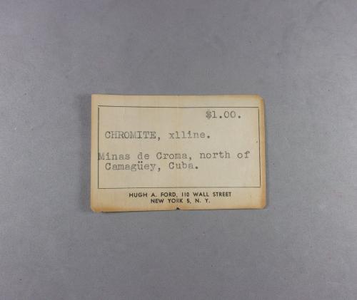 _Cromita, etiqueta.<br />Distrito Camagüey, Provincia Camagüey, Cuba<br />7,2 x 4,7 x 2,8 cm.<br /> (Autor: J. G. Alcolea)