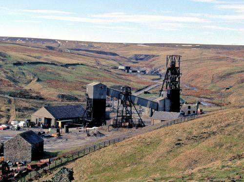 Frazer’s Hush was a modern mine, operating between 1974 - 1999. It was located at the far northwest end of Rookhopeburn, just beyond the Groverake Mine. The workings can be seen in the middle background of the photo, just left of the main Groverake head frame. The Frazer’s Hush workings were declines rather than shafts, so no head frames were erected on site. The mine is best known for a find of high quality purple fluorites that happened in 1987-1988. The photo was taken in 1999 shortly after the closure of both mines. The sites have largely been cleared since, and the only thing that now remains is the main Groverake head frame. (Author: Jesse Fisher)