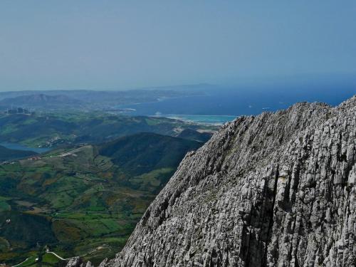 Vista al oeste desde la cima con el puerto de Tanger Med en el centro y el Cabo Espartel al fondo.

La estratificación, aquí en posición vertical, es entre decimétrica y métrica. (Autor: Josele)