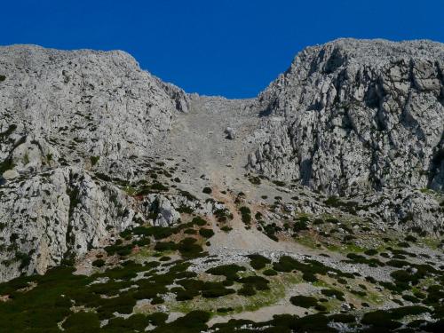 Subiremos por el canchal (tartera) que se abre paso entre dos peñones de calizas claras de edad Jurásica (Lias inferior) (Autor: Josele)