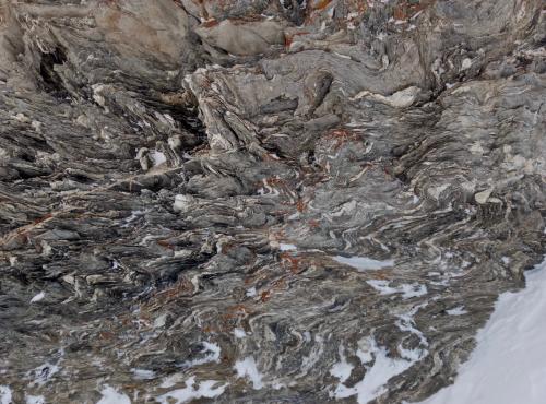 _Parece ser un gneiss muy replegado resultado del metamorfismo de alto grado de un esquisto biotítico. Por fundir antes que el resto de minerales que forman el esquisto, el cuarzo de segregación se acumula formando almohadillas. (Autor: Josele)