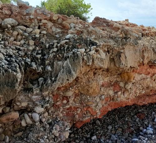 Detalle de la foto anterior. En la zona central encima de los conglomerados se depositó un nivel de arena fina, ahora muy endurecida por la compactación formando una playa fósil cubierta más tarde por otro nivel de conglomerados que ahora se está desmantelando por efecto de la erosión.
Cala Maria, Cap Roig, L’Ampolla, Baix Ebre, Tarragona (Autor: Frederic Varela)