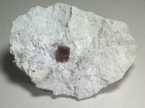 Red Beryl. Utah. Translucent crystal with very even red color.  17.5 x 11.9 x 6.7 cm overall.  2.1 x 1.4 x 1.6 cm crystal. (Author: GneissWare)