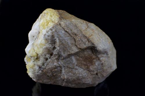 The back of the specimen, primarily a limestone matrix with the yellow fluorite and white calcite covering one side. (Author: k-m.minerals)