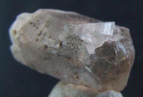 Phenakite on smoky quartz, Smoky quartz 6 x 2.5 mm  Phenakite crystal about 1 mm Mt Antero Colorado. (Author: nurbo)