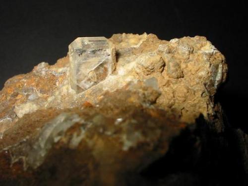 Nice colorless baryte crystal (1,2 cm with hematite inclusions) on alterated dolomite from the Gehn quarry, Uffeln, Munsterland, Westphalia. (Author: Andreas Gerstenberg)
