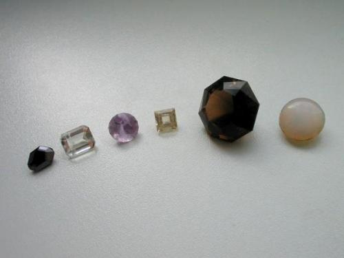 German cut stones. From the left to the right: magnetite (3,1 ct) from Volkesfeld, Eifel mts. - sanidine (3,2 ct) from the same locality - amethyste (2,7 ct) from Seidelgrund, Wiesenbad, Erzgebirge, Saxony - topaz (1,9 ct) from Schneckenstein, Saxony - smoky quartz (23,6 ct) from Elzing quarry, Limbach, Saxony  - opal from Eibenstock, Saxony which has been a well-known deposit for gemmy opals in the past. (Author: Andreas Gerstenberg)
