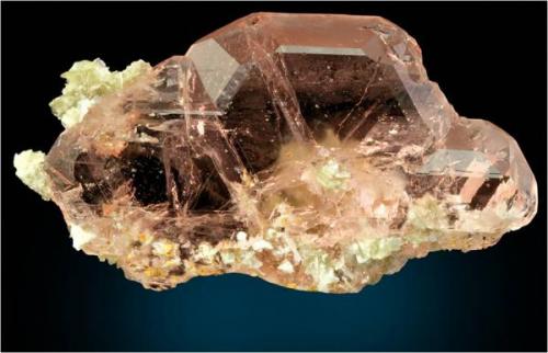 What on first glance looks like morganite is actually a gemmy light pink/red spinel twin fluorite from Gilgit , Pakistan with some minor clusters of muscovite. This measures 9.8 x 5.5 x 3.5 cm and weighs around 125 grams. (Author: VRigatti)