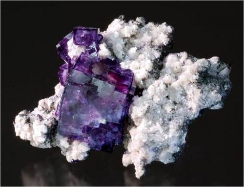 A cluster of dark purple, gemmy fluorites on muscovite matrix from Yaogangxian Mine, Hunan province China. It measures 6.5 x 5.8 x 3.5 cm and weighs 65 grams. (Author: VRigatti)