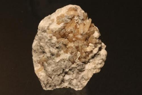 Cristales de ¿aragonito? (2x12mm) en matriz de yeso sacaroideo. Pieza de 47x35 mm. Recogido en Colmenar de Oreja (1991). (Autor: Ivan Blanco (PDM))