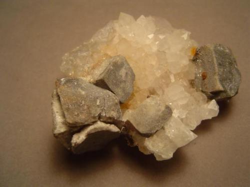 Same specimen, from the side.  Note that the galena cube has undergone expansion when it altered to anglesite and cerussite. I like these expanded galena cubes, in part because they are the opposite of exfoliation, the weathering process that produces rounded boulders.  Microcrystalline cerussite makes the ex-galena surfaces glitter.  Gift of Dr. Peter Megaw (Author: Ed Huskinson)