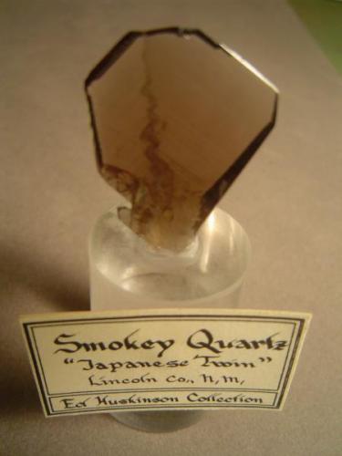Quartz, variety smoky (and twinned in the Japanese style)  Lincoln County, New Mexico.  Acquired from Dick Jones, 1980.  The crystal is 3.2 cm tall, and is 2.5 cm at it’s widest point. (Author: Ed Huskinson)