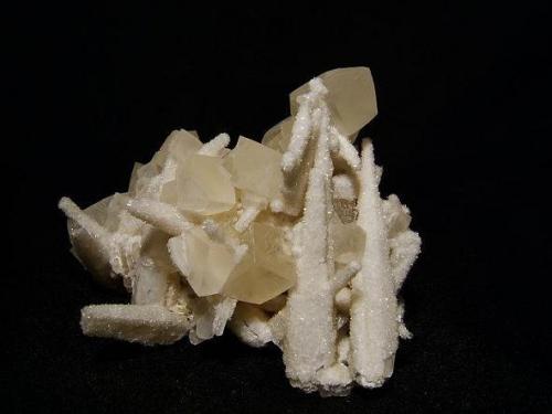 Calcite + stilbite
Camas na h-Uamha (Bay of Caves), Duirinish, Isle of Skye, Scotland, UK
Specimen is 75 mm wide and 55 mm high.

This specimen is from a different locality, though again it was in a vein cavity in basalt. There are THREE different forms of calcite here, though only two are represented on this specimen. The earlier scalenohedral calcites are coated with micro-crystallised stilbite, with simple later calcite rhombs on top; a rather beautiful combination. Specimen is 75mm wide and 55mm high. By the way, that calcite scalenohedron near the bottom left that sticks out leftwards - is stuck back on - in this case it was probably an unnecessary repair! Self-collected 1998 from Camas na h-Uamha (Bay of Caves), Duirinish, Isle of Skye. (Author: Mike Wood)