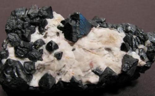 Franklinite on calcite matrix. Sterling Hill Mine, Ogdensburg, New Jersey. 7 x 4 x 4 cm. Main crystal 1,5 cm on edge. (Author: Antonio Alcaide)