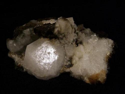 Analcime + chabazite. A large analcime crystal 34mm wide with smaller grey analcimes, and white chabazite crystals to 10mm. Also there are a few small stilbites and some brownish calcite. Specimen measures 10cm x 7cm x 4cm high. Self-collected 2002 from Talisker Bay, Isle of Skye, Scotland. (Author: Mike Wood)