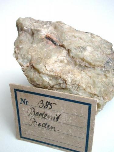 Brownish bodenite, a Mg-bearing variety of allanite-(Y) in oligoclase from Boden limestone quarry, Marienberg, Saxony. 1 cm crystal. With 1926 label. (Author: Andreas Gerstenberg)