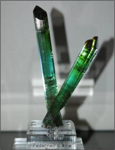 A pair of crossed tourmalines from Pederneira Brazil. The largest crystal is 13.5 cm long x 2.0 cm with 2 repairs. The smaller crystal has no repairs. Weight is 90 grams. Sorry about the photo quality (Author: VRigatti)