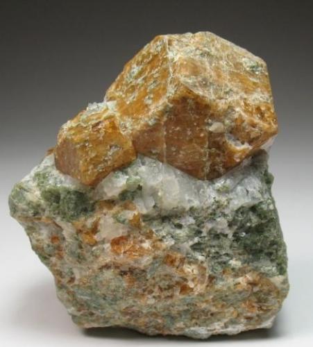 Grossular. 
Maine, USA
6 x 5 cm. 
Main crystal measures 3 cm. With Calcite and maybe Actinolite.
It could be from Casco or Limerick. See: http://www.mineral-forum.com/message-board/viewtopic.php?p=37646#37646 (Author: Antonio Alcaide)