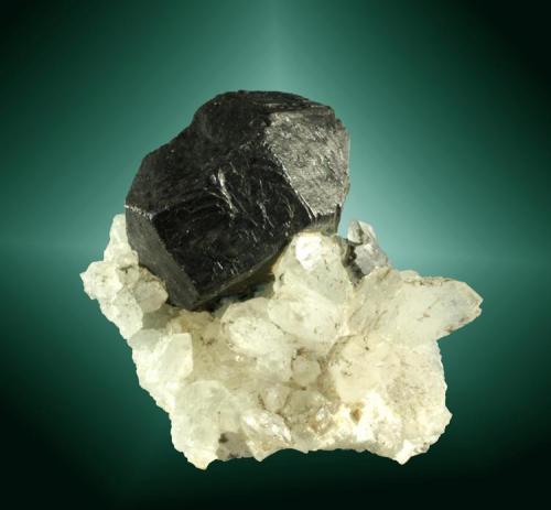 Galena + Calcita
Linares, Jaén, Andalucía.
Cristal cubo-octaédrico deformado, en un grupo de cristales de calcita.
3,0 x 3,1 x 1,7 cm. / cristal: 1,9 x 1,4 x 1,3 cm.
(junio de 1968 / recolección personal). (Autor: Carles Curto)