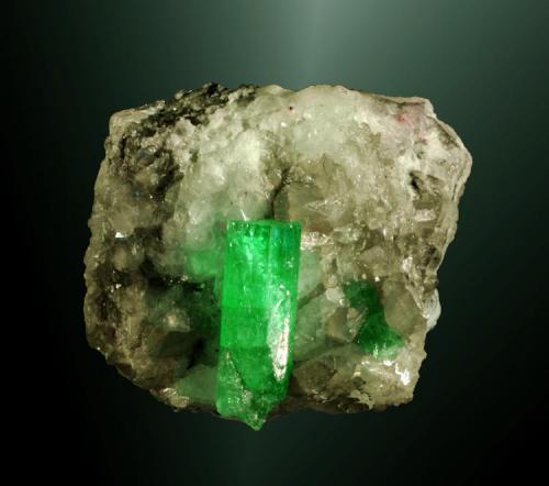 Berilo (esmeralda) + calcita
Muzo, Vasquez-Yacopí (distr.), Boyacá (dept.), Colombia. Coscuez (m).
Cristal prismátic terminado en pinacoide, transparente, en matriz de calcita blanca cristalizada (ejemplar de 2005).
4,2 x 4,5 x 3,1 cm. / cristal: 2,3 x 0,8 x 0,7 cm. (Autor: Carles Curto)