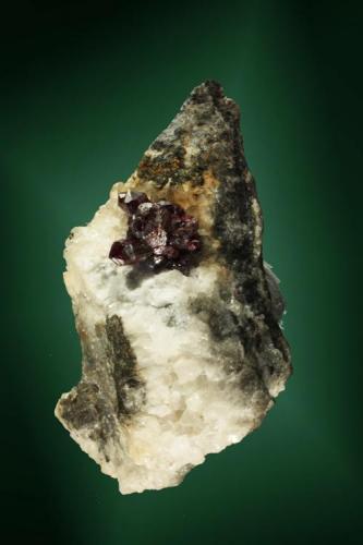 Proustita + Calcita
Chañarcillo, Atacama, Chile. Dolores (m).
Agregado de cristales prismáticos con calcita, en matriz (ejemplar de 1968).
tamaño: 3,2 x 2,1 x 1,8 cm. / cristal pral.=  0,4 x 0,1 x 0,1 cm.
El ejemplar ha figurado en distintas publicaciones. (Autor: Carles Curto)