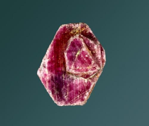 Corindón (rubí)
Andranomilitsy (Vohitany), Ioshi (distr.), Toliary (prov.), Madagascar.
2,3 x 1,6 x 1,2 cm. / cristal pral.= 2,3 x 1,6 x 0,8 cm.
Cristal tabular grueso, con sobrecrecimientos en pirámide, con caras triangulares terminales muy marcadas.
Ejemplar obtenido en 1973. (Autor: Carles Curto)