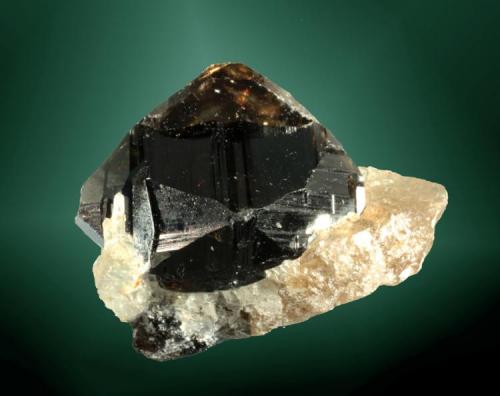 Casiterita
Amo, Ximeng Wa, Simao (pref.), Yunnan (prov.), China. Amo Sn (m).
4,0 x 2,8 x 2,5 cm. (ejemplar) / 3,2 x 2,7 x 2,5 cm. (cristal)
Cristal equidimensional maclado, negruzco con áreas muy transparentes, en matriz de cuarzo.
Ejemplar de 2006 (Autor: Carles Curto)
