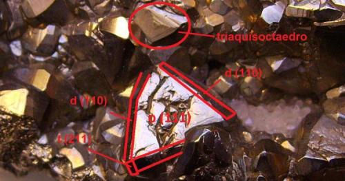 Pirita
Distrito de Julcani, Provincia de Angaraes, Departamento de Huancavelica, Perú
6,5 x 4,5 x 2,5 cm.
Índices de Miller dibujados sobre un octaedro de la pieza anterior. Aparecen las caras del octaedro (111), rombododecaedro (110) y trapezoedro (211) -dos pequeñas caras al final de los rombododecaedros-. Señalado con un círculo sobre un octaedro las líneas de crecimiento de lo que iba a ser un triaquisoctaedro (una pirámide que tiene como base dicha cara del octaedro). Ver foto de Mindat citada. (Autor: Antonio Alcaide)