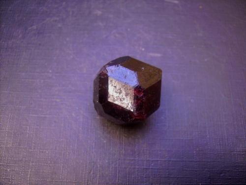 Almandino
Bella Vista Mine, Mitkof Island, Wrangell-Petersburg borough, Alaska, EEUU
2,2 x 2 cm.
Este cristal está formado por rombododecaedros {110} biselados, es decir, modificados por el traezoedro {211}. Hay en el yacimiento formas más complejas, trapezoedros modificados, de los que no dispongo. (Autor: Antonio Alcaide)