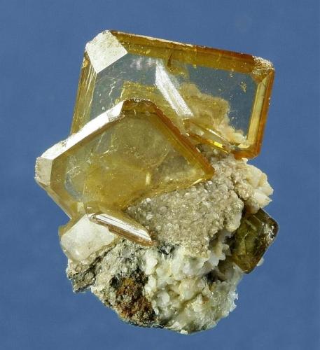 Wulfenite
Tsumeb Mine, Tsumeb District, Oshikoto Region, Namibia
20 x 20 x 18 mm
Two light-straw-yellow Wulfenites are attractively perched on a small piece of matrix. Several small wulfenites are also present. The main crystal is 1.4 cm and is undamaged. Minor edge wear is present on some of the smaller Wulfenites. This is a rare color from Tsumeb. (Author: GneissWare)
