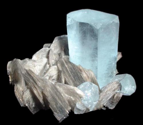 Berilo, moscovita
Chumar Bakhoor, Hunza Valley, Gilgit-Baltistan, Pakistan
100 mm x 95 mm

La cara {2111} en forma triangular se puede observar en la parte superior del cristal principal, en contacto con el pinacoide {1000} y las caras laterales {1100}. (Autor: Carles Millan)