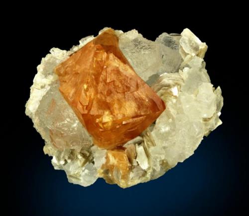 Scheelite with Fluorite
Mt. Xuebaoding, Pingwu County,  Mianyang Prefecture, Sichuan Province, China
80.0 x 70.0 x 60.0 mm overall
A beautiful perfect orange Scheelite crystal 4.5 cm across is set perfectly amongst colorless translucent crystallized fluorite, this all on a Muscovite matrix. No damage. (Author: GneissWare)