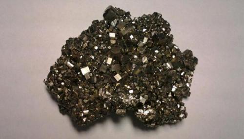 Pyrite (Cubical)
Racracancha Mine, Tinyahuarco District, Cerro de Pasco Province, Department of Pasco, Perú.
83 mm x 63 mm x 26 mm
Group of cubic Pyrite crystals that when they receive sunlight become somewhat iridescent. (Author: Gianfranco Rodríguez T.)