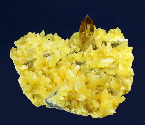 Barite on Calcite
Elk Creek, Dalzell, Meade Co., South Dakota, USA
84 x 78 x 51 mm

A gorgeous, lustrous, gemmy, transparent, deep-amber-colored orthorhombic Barite crystal measuring 24 mm in length is set perfectly upon a matrix covered by pretty yellow crystallized Calcite to 14 mm. The Barite has a classic, razor sharp, chisel termination. The piece is perfectly proportioned and sits by itself for display. No damage. (Author: GneissWare)