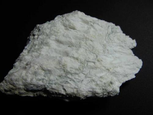 Magnesita
Siegen, Alemania
7’5 x 5 x 3’5 cm.
Agregado masivo con cierto aspecto fibroso y color blanco apagado.  Se reconocen zonas verdosas (probablemente de minerales de serpentina). (Autor: prcantos)