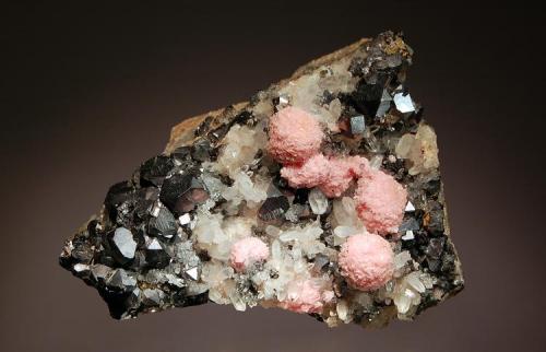 Rhodochrosite
Osikovo Mine, Madan District, Smolyan Oblast, Bulgaria
6.0 x 9.0 cm
Spherical groups of pink rhodochrosite scattered among quartz crystals and cubeoctahedral galena. (Author: crosstimber)